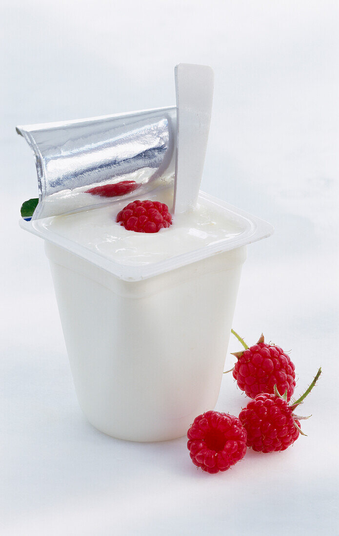 A cup of natural yogurt with fresh raspberries