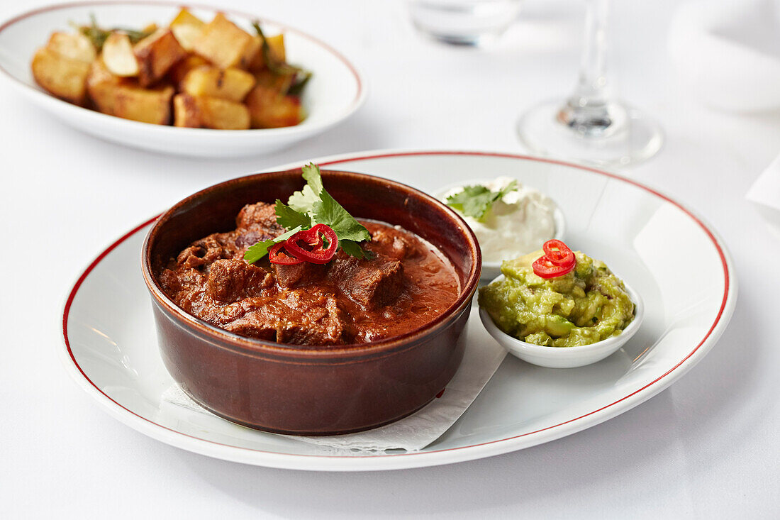 Braised beef with guacamole and crispy fried potatoes