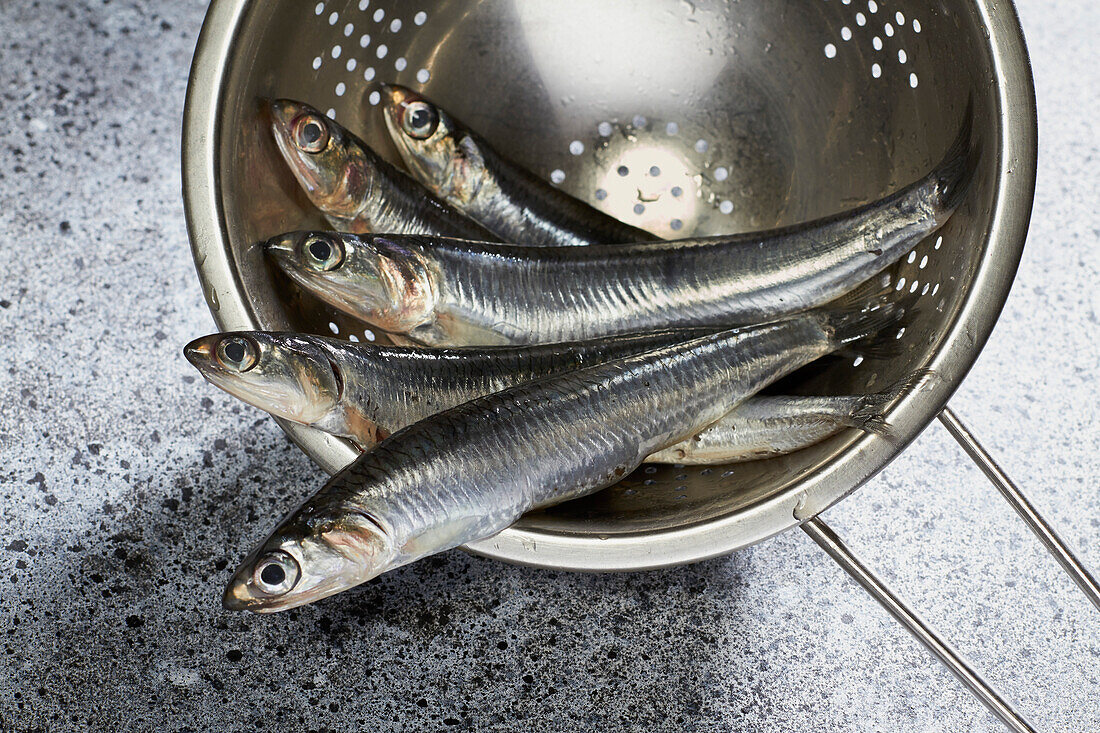 Fresh anchovies in a metal colander