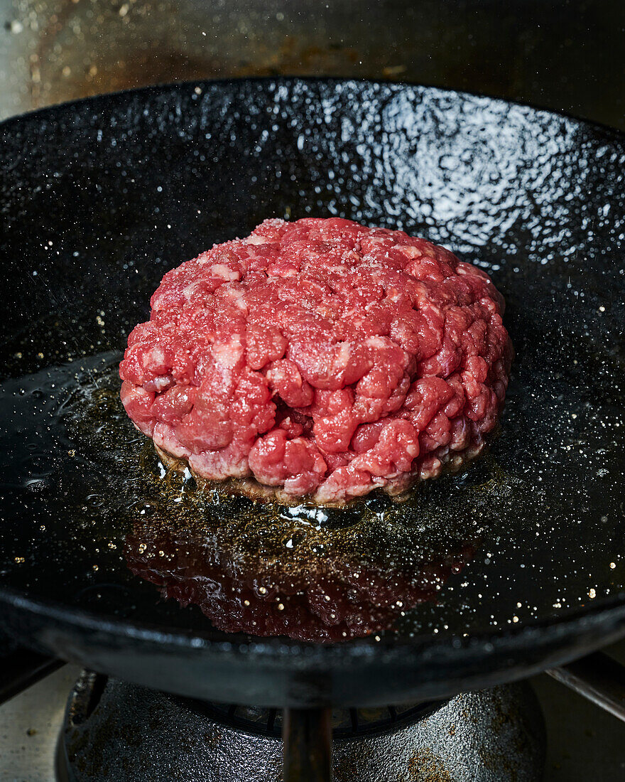 beef burger in a frying pan