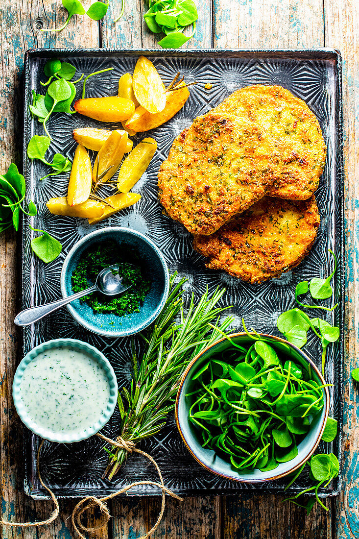 Kräuter-Sellerieschnitzel mit Kartoffelspalten und Winterportulak