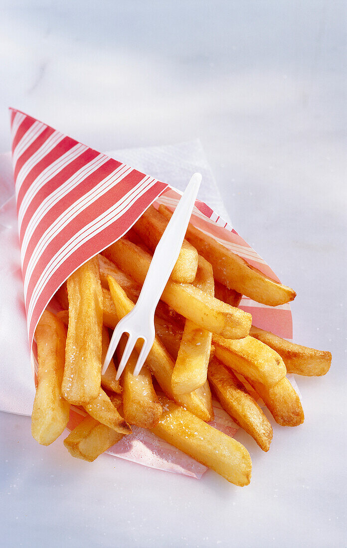 Red and white striped paper bag with French fries and a plastic fork