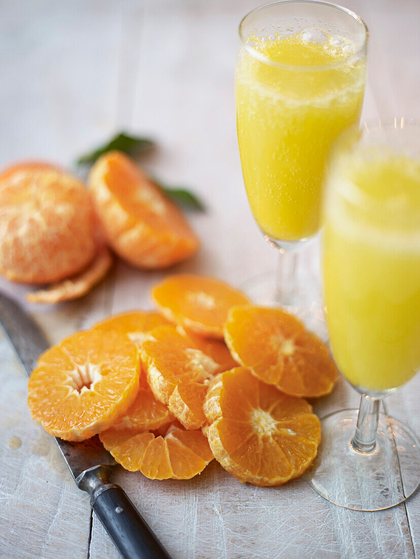 Orange slices and two glasses of sparkling orange juice