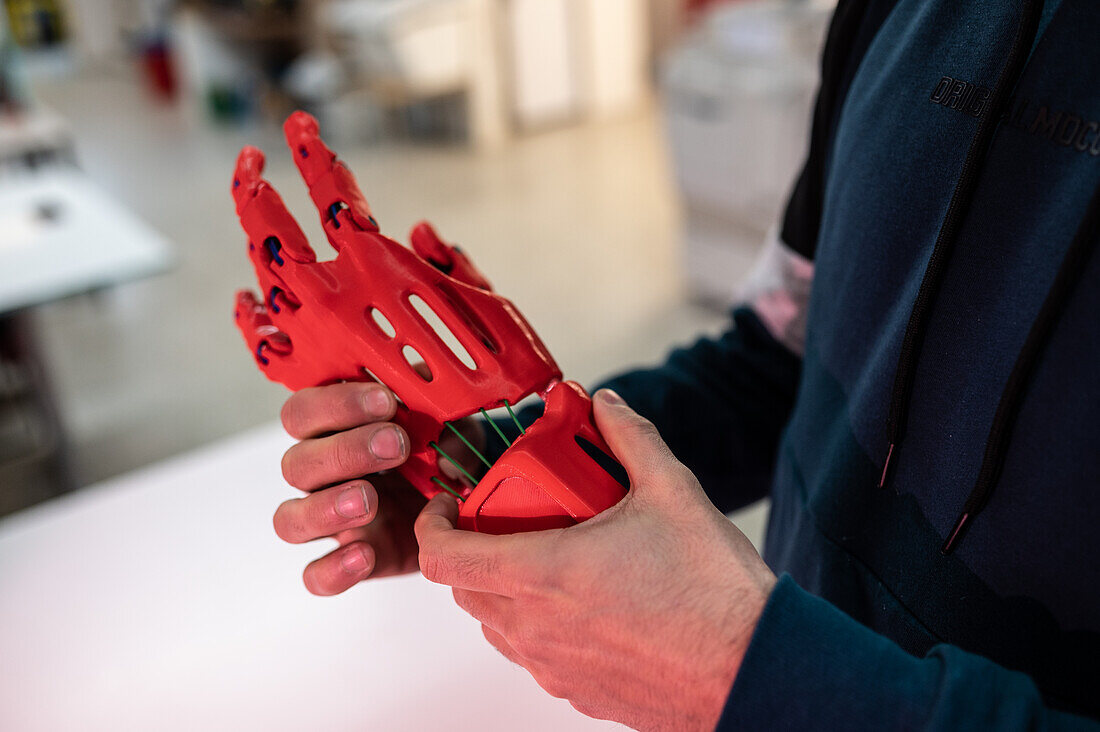 Man holding a 3D printed plastic hand prosthesis