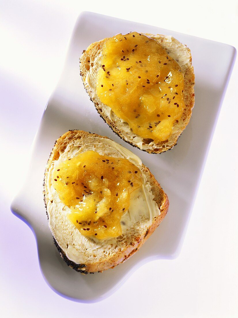 Two halves of poppyseed roll with banana and kiwi fruit jam