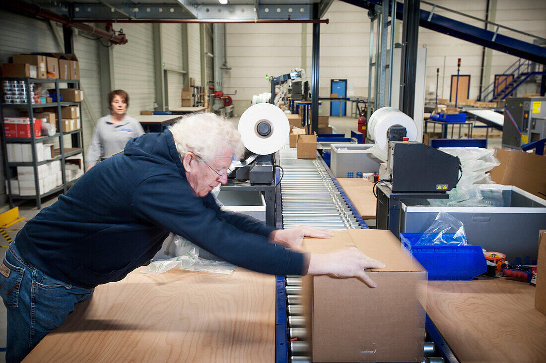 Man packaging a client order in a warehouse.