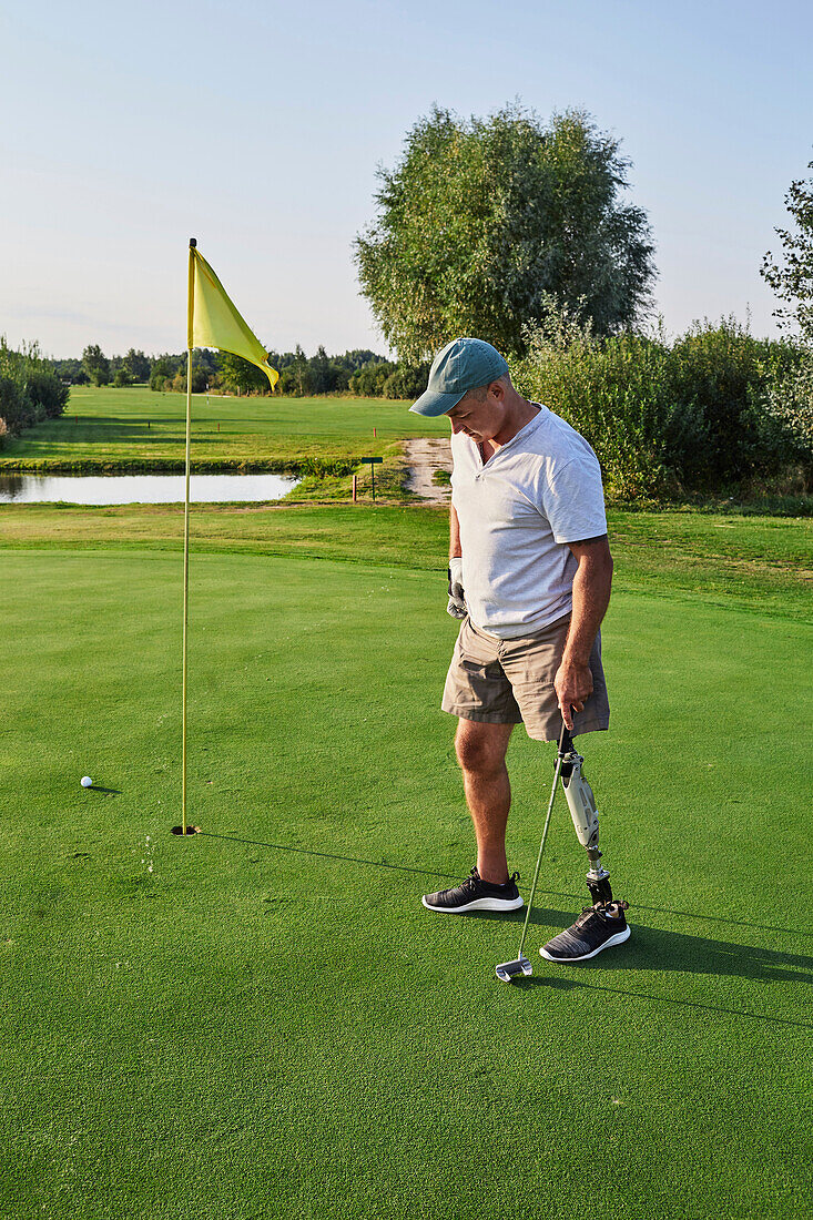 Man with prosthetic leg playing golf