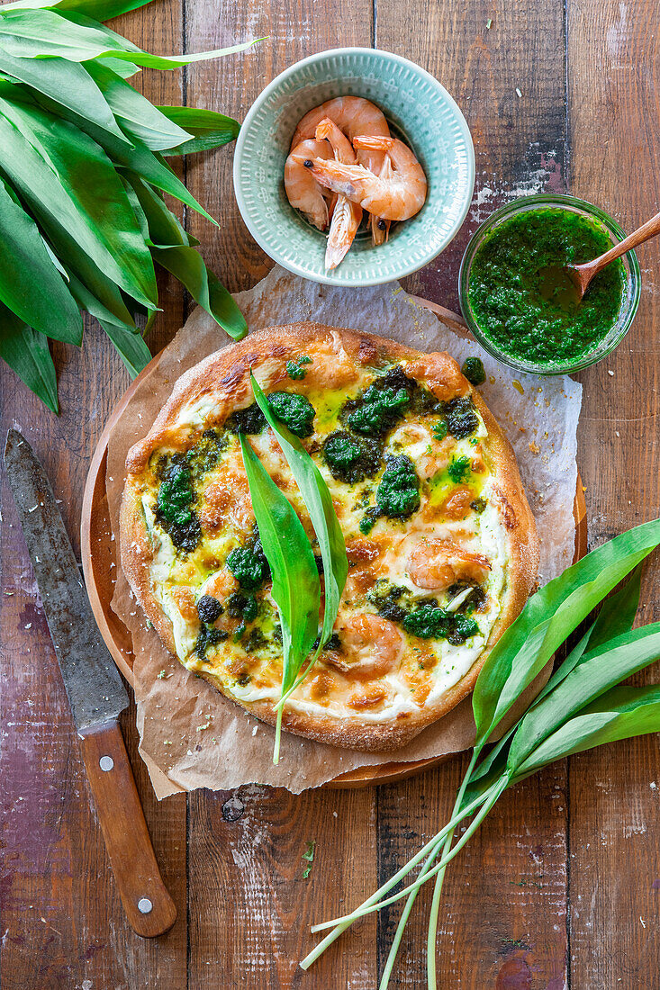 Pizza with wild garlic, prawns and wild garlic oil