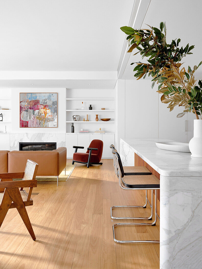 Marble kitchen island with bar stools in bright open plan living room