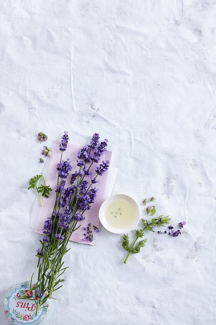 Lavender blossoms, rose geranium leaves, small bowl with aromatic oil, clary sage blossoms