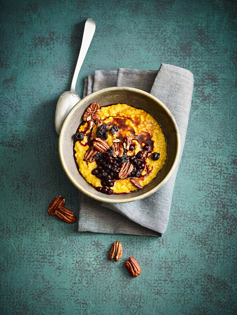 Sweet pumpkin porridge with pecan nuts and berries