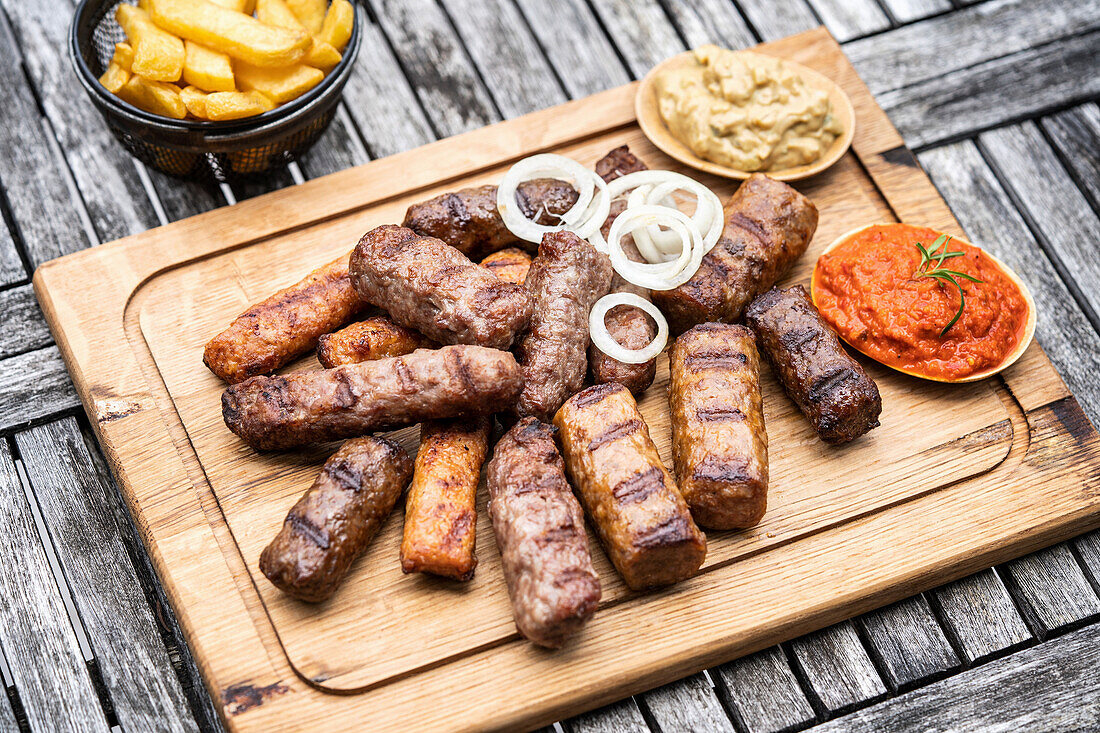 Grilled Ćevapi with onion mustard, ajvar, and French fries