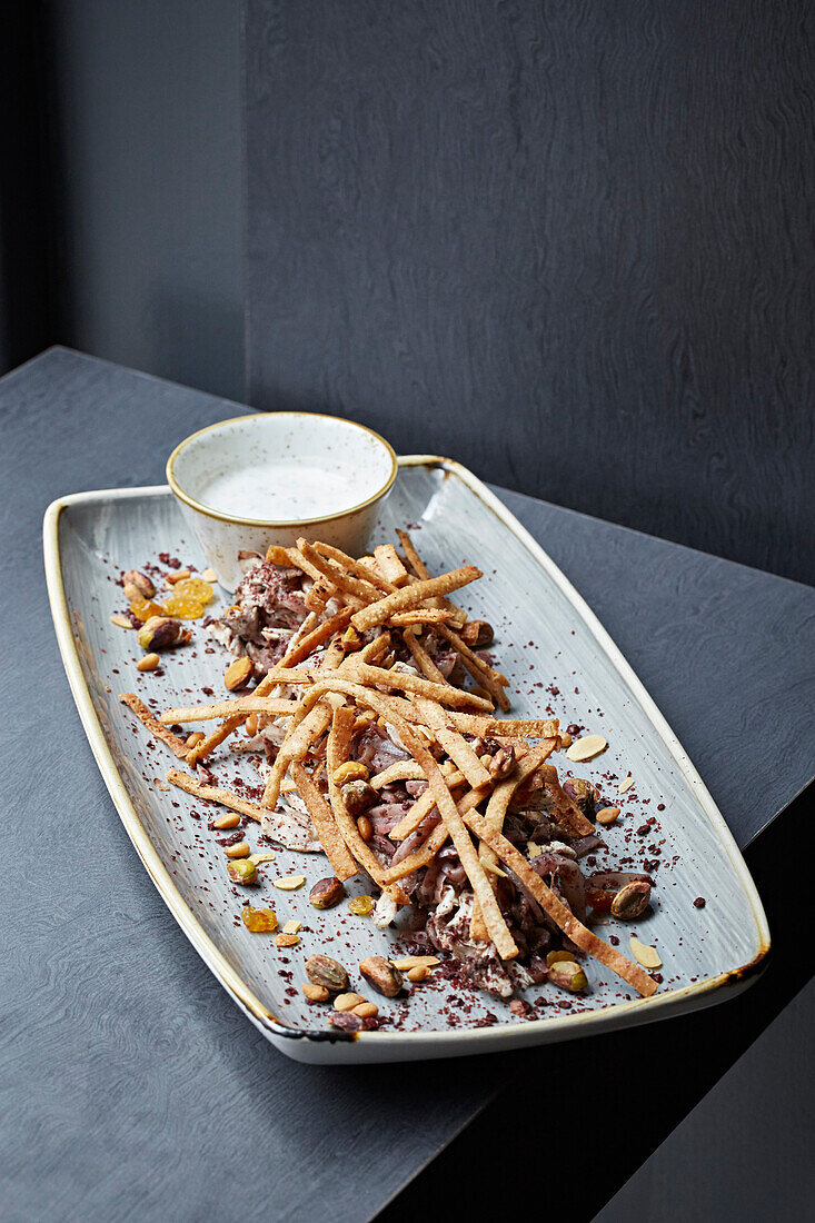 Chicken and red onion with currants, crispy bread and pistachios