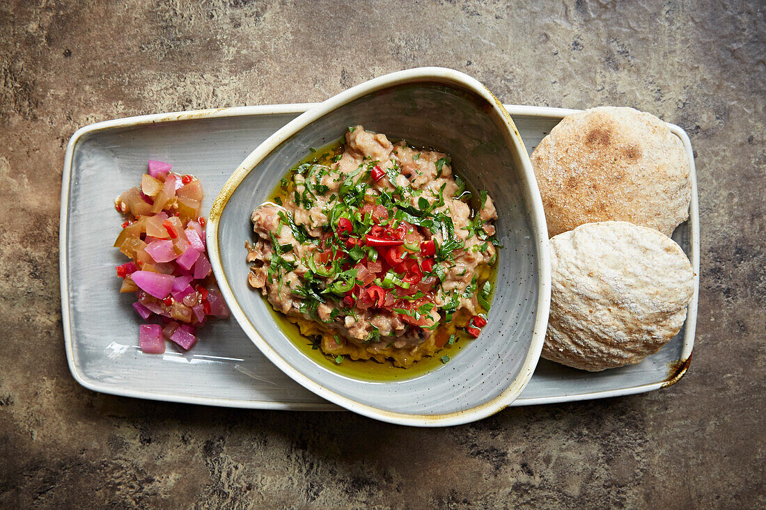 Hummus in einer Schüssel mit Salat und Fladenbrot