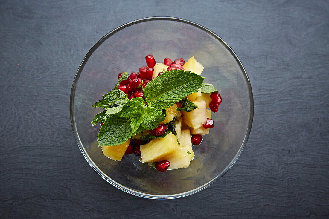 Pineapple and pomegranate pudding with fresh mint