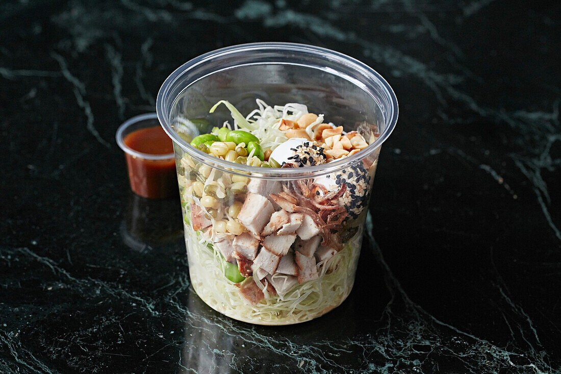 A healthy bowl with chicken, quail eggs and edamame to take away