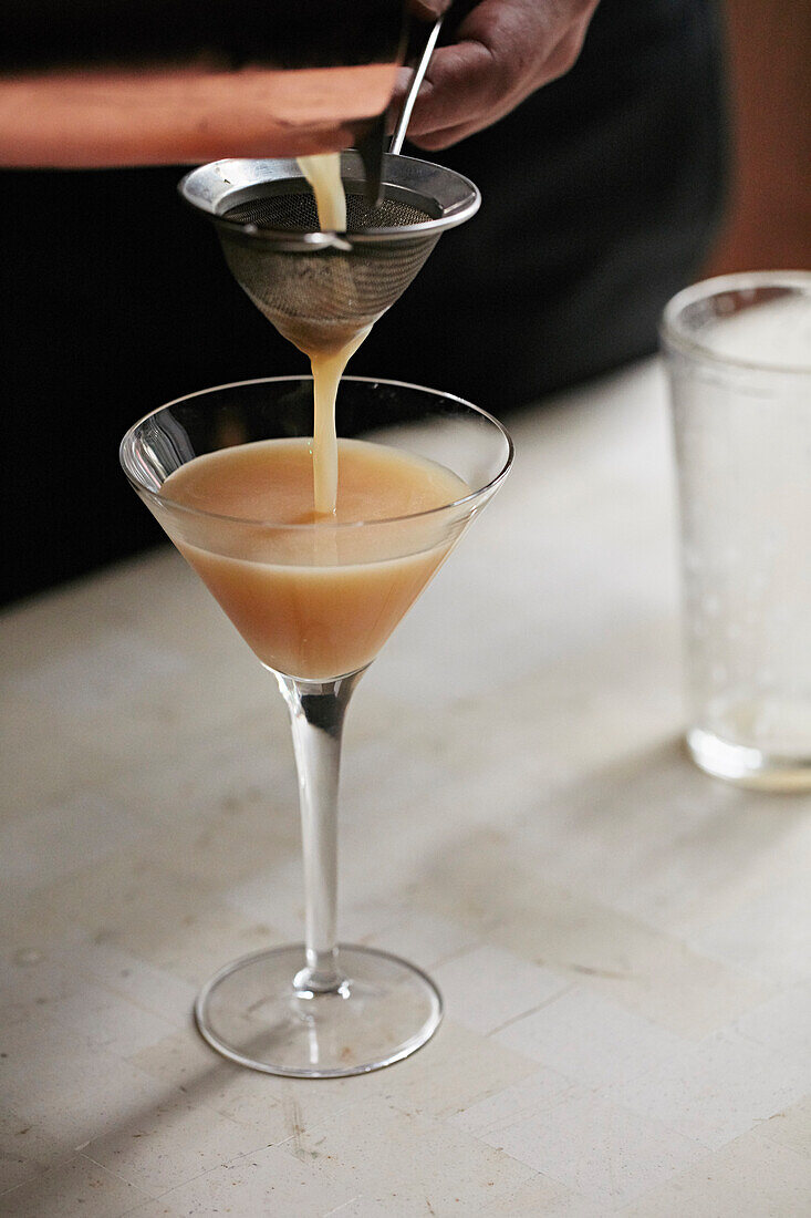 A whisky sour cocktail being poured