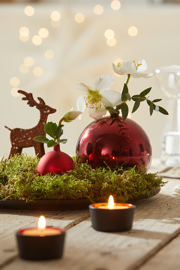 Christmas table decoration with reindeer, tea lights and Christmas roses