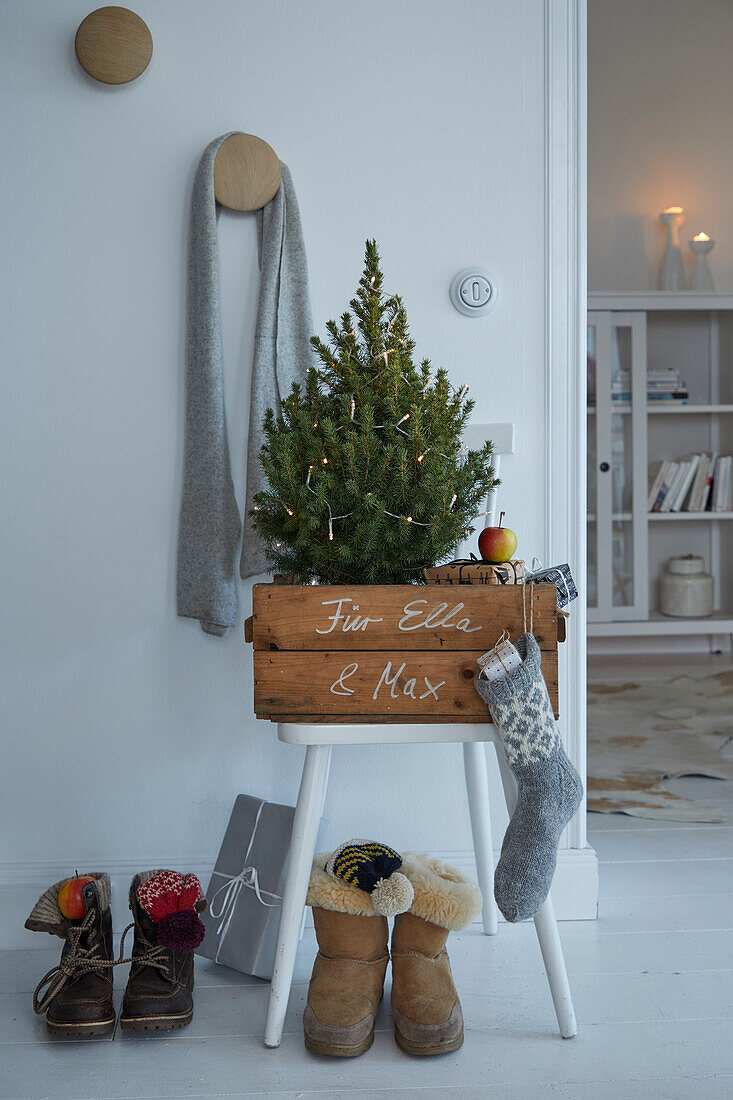 Weihnachtlich dekorierte Ecke mit kleinem Tannenbaum und Geschenken