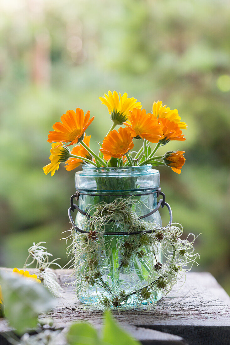 Ringelblumenstrauß im Bügelglas mit Herz aus Clematis