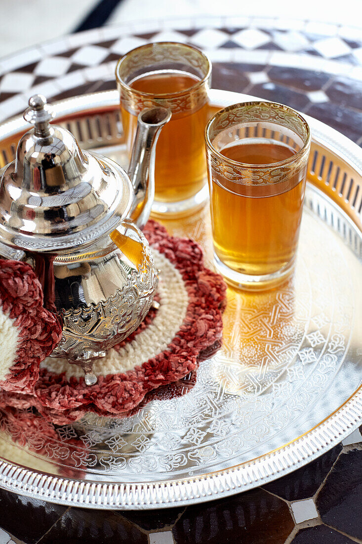 Teekanne und zwei Gläser orientalischer Tee auf Silbertablett