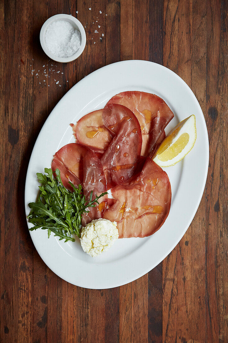 Bresaola slices on a plate with lemon