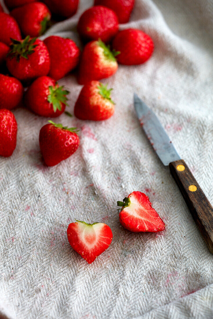 Fresh strawberries with a knife on a kitchen towel
