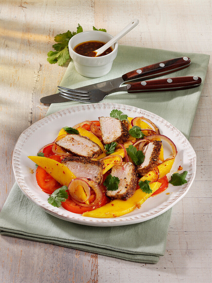 Salad with pork loin, mango and tomatoes