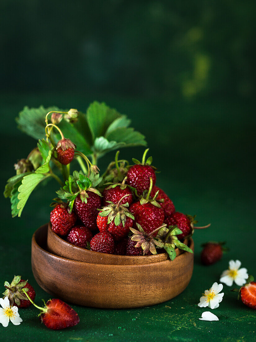 Strawberries and wild berries in a wooden bowl