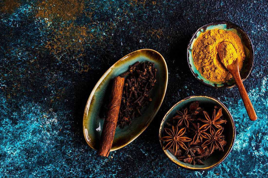 Turmeric, star anise, cloves, and cinnamon stick in bowls