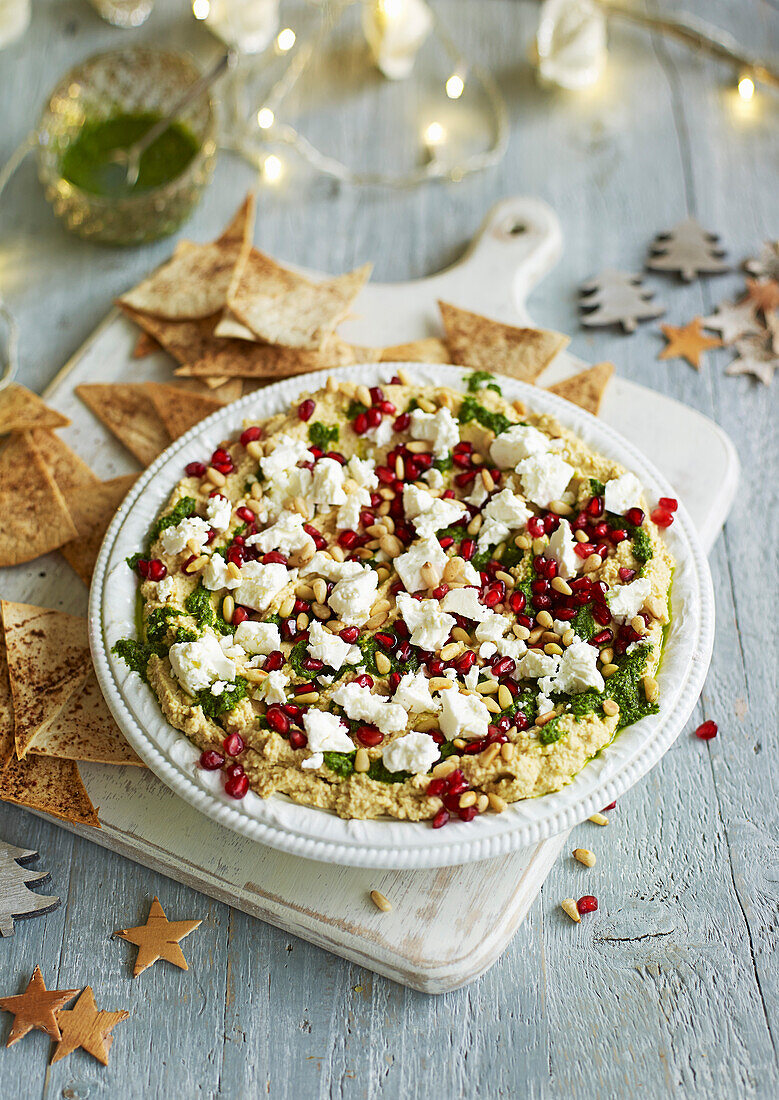 Geschichteter Hummus Feta, Granatapfelkernen und gewürzten Tortilla-Chips