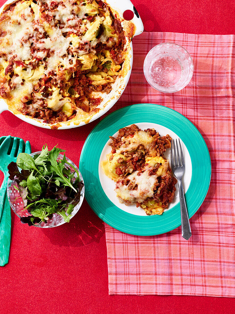 Baked ravioli with bolognese sauce and a side salad
