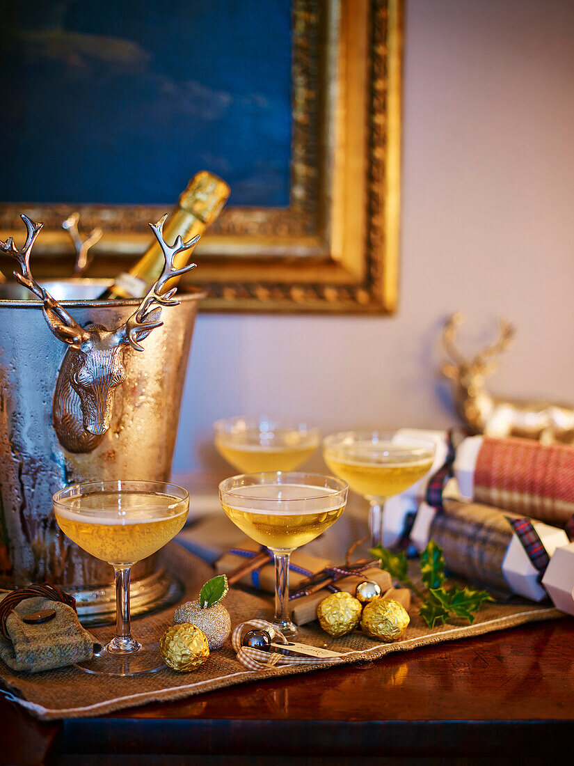 Champagner in Gläsern auf weihnachtlich dekoriertem Beistelltisch