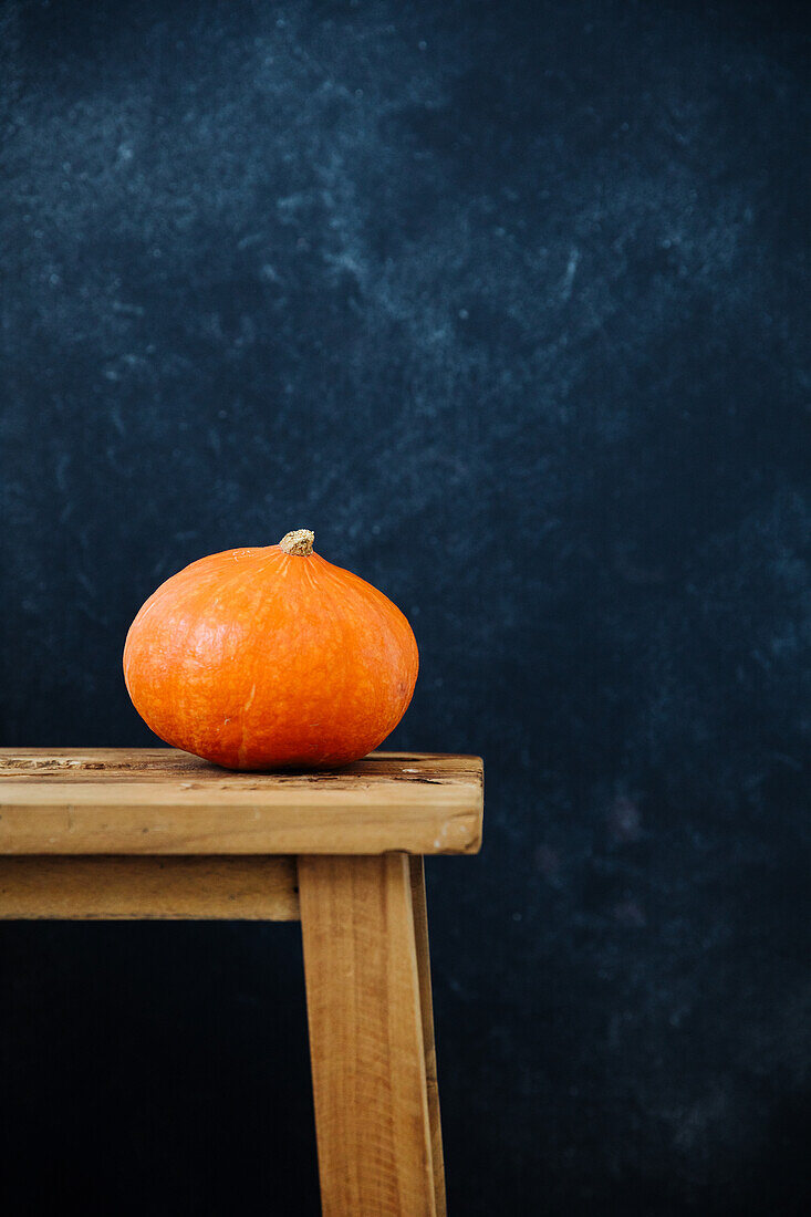 A Hokkaido pumpkin on a wooden bench