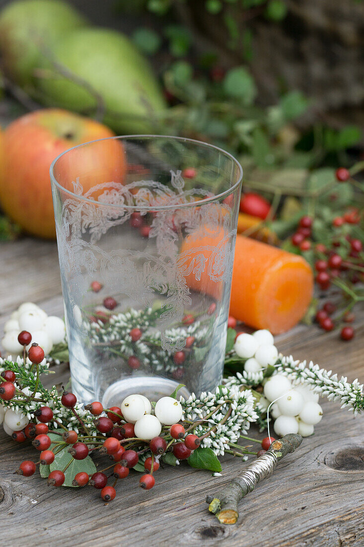 Kleiner Kranz aus Schneebeeren, Hagebutten und Heidekraut um Windlicht