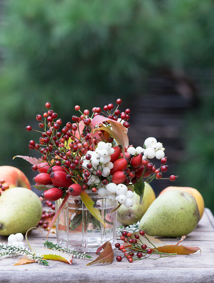 Bouquet of snowberries, rosehips, vinegar tree leaves and heather, with pears