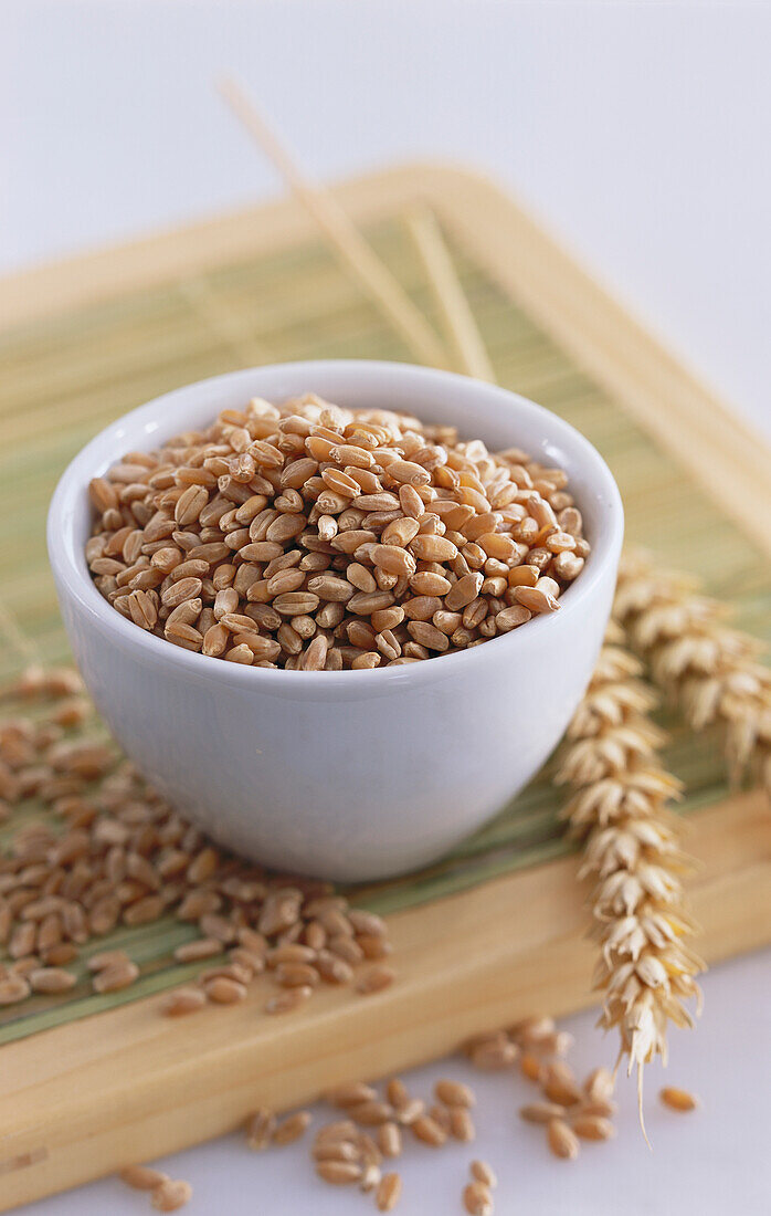 Bowl with wheat grains next to it wheat ears