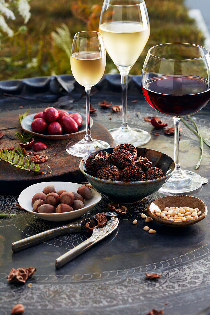 Wein und Nüsse auf Tisch im Freien
