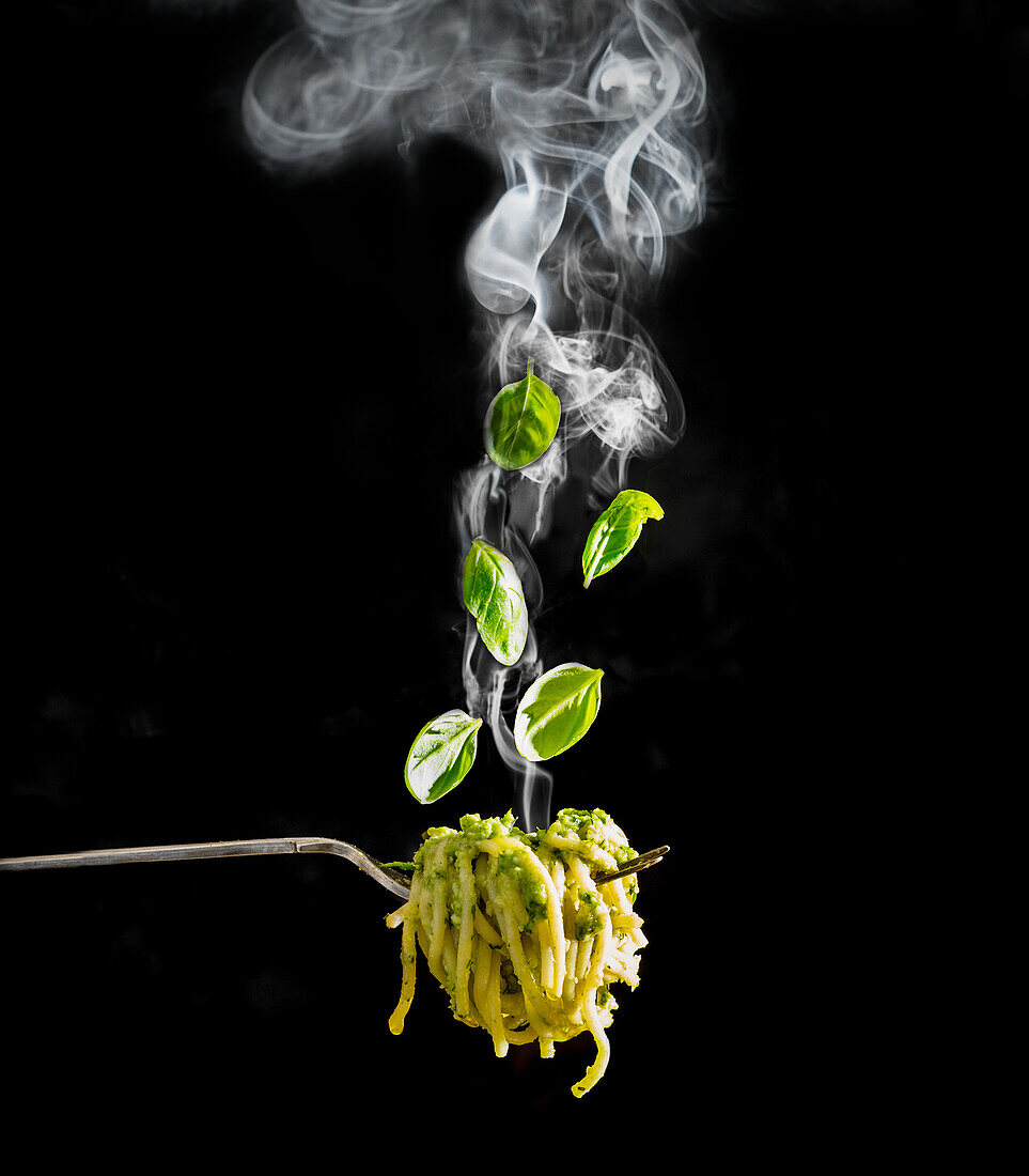 Dampfende Pesto-Nudeln mit Basilikumblättern