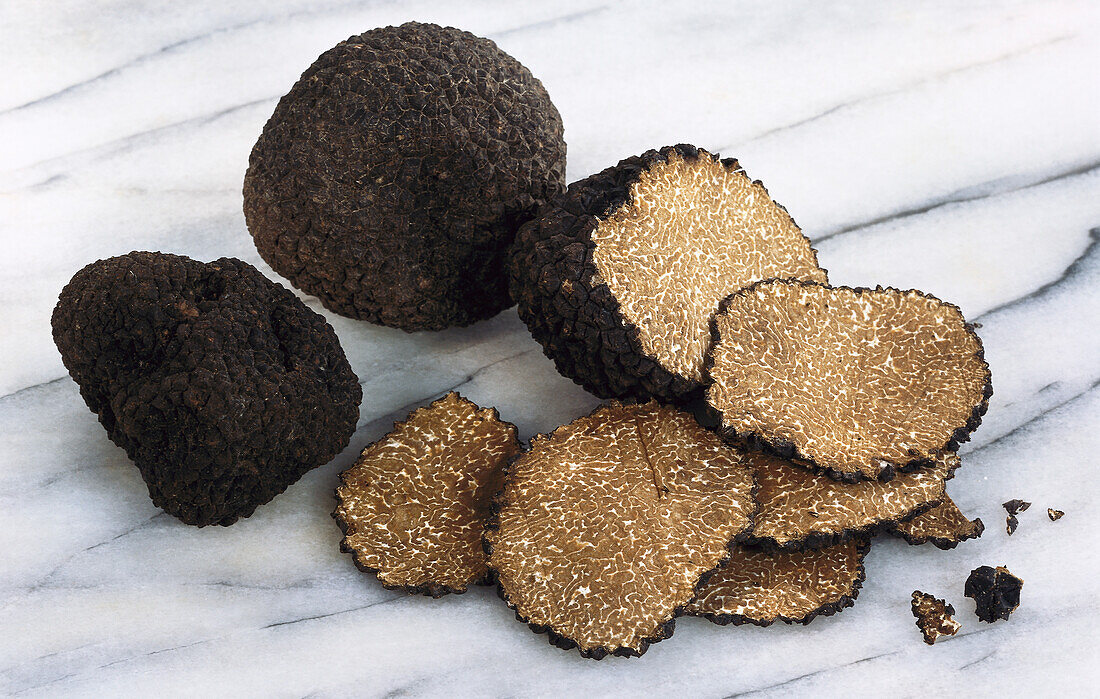 Summer truffle and truffle slices on a marble background