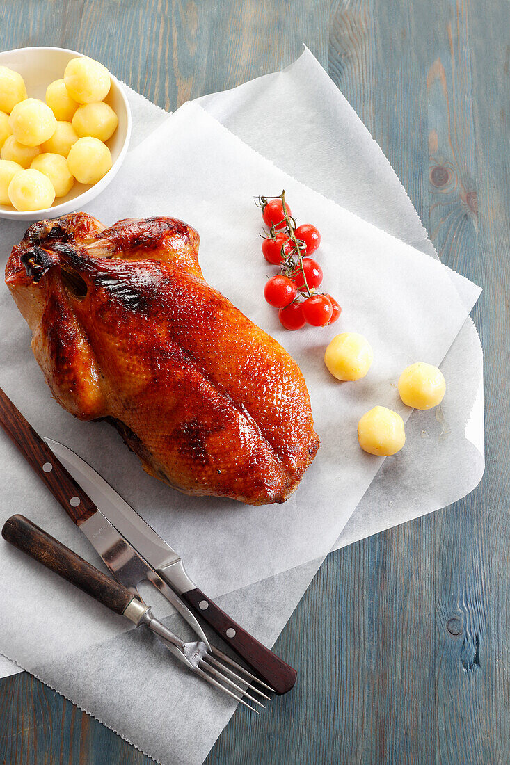 Roast duck with potatoes and cocktail tomatoes