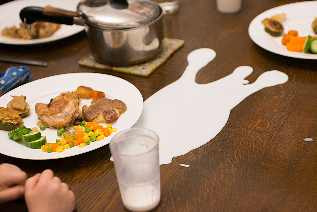 Tasse verschüttete Milch auf dem Esstisch