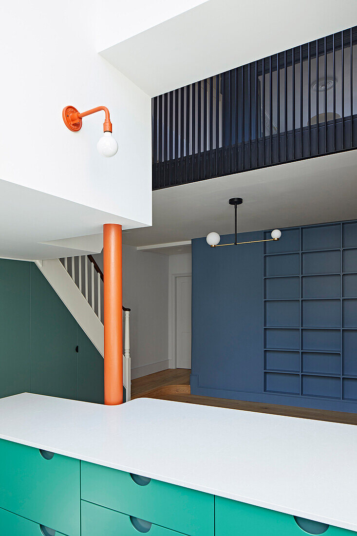 Custom-made kitchen with green cabinet fronts and view of the mezzanine floor