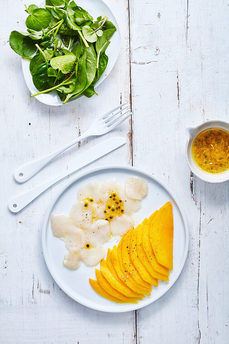 Dünne Jakobsmuschelscheiben mit Mango-Carpaccio und Mangodressing