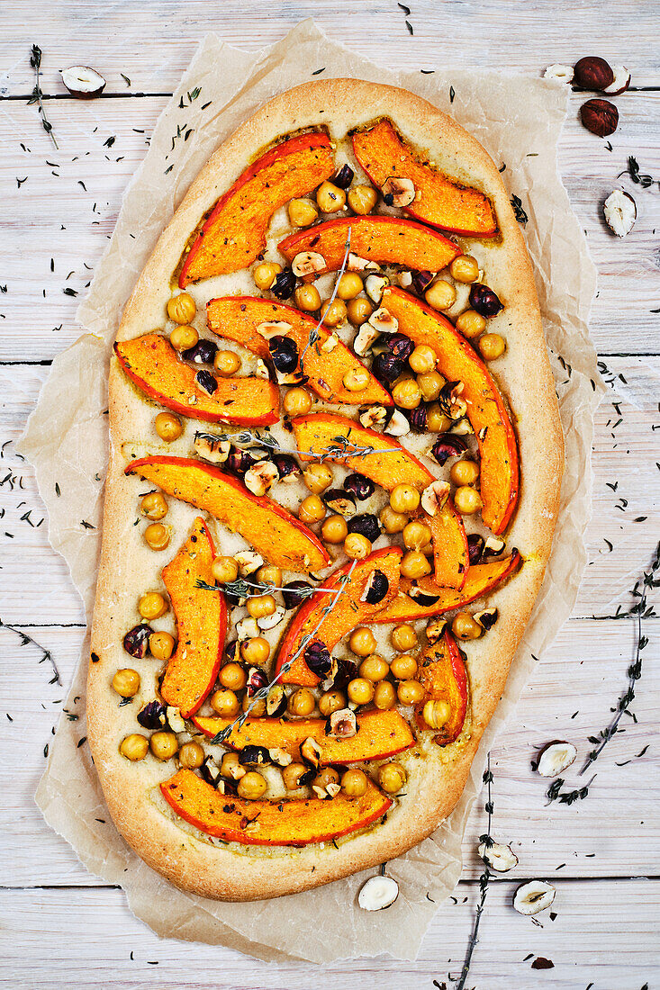 Vegan chickpea pizzette with pumpkin and hazelnuts