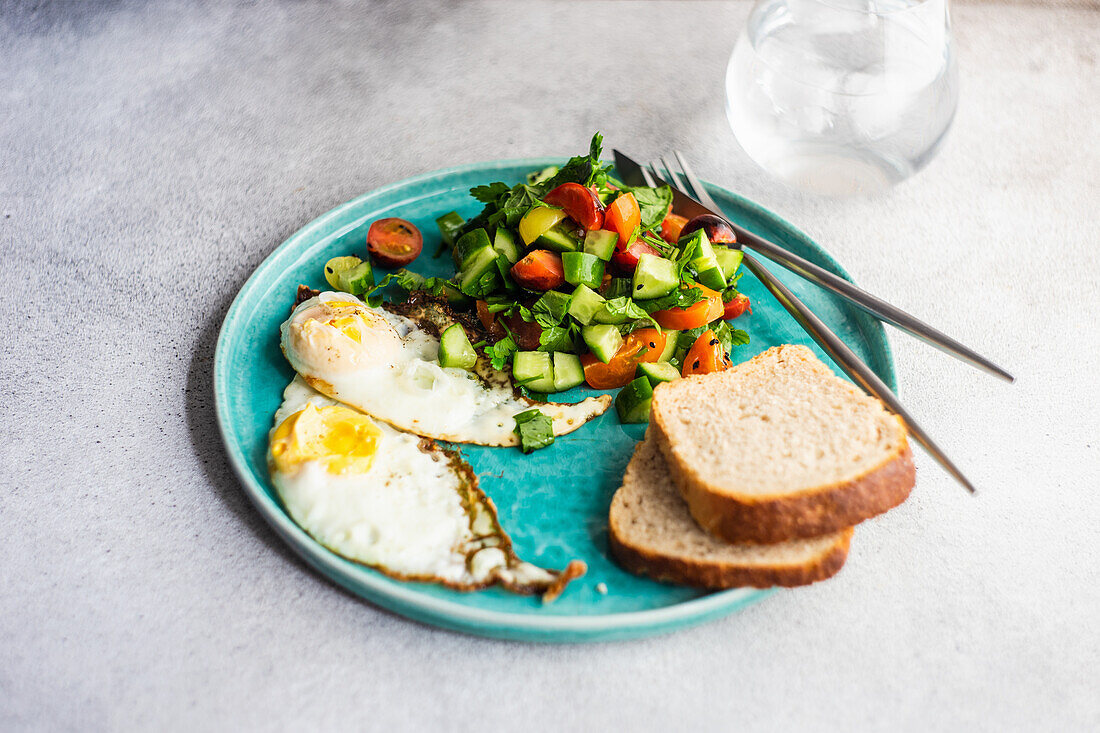 Healthy lunch set with fried eggs and fresh vegetable salad served on the plate