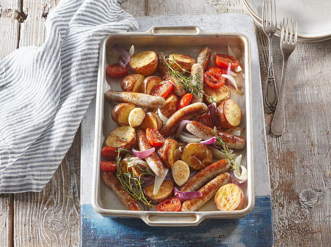 Ofengebackene Würstchen mit Kartoffeln und Tomaten