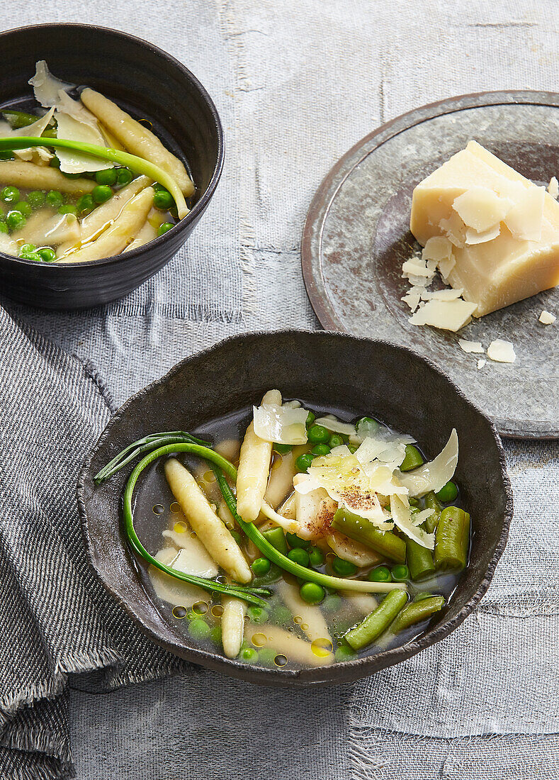 Klare Brühe mit Parmesan-Gnocchi, Spargel und Erbsen