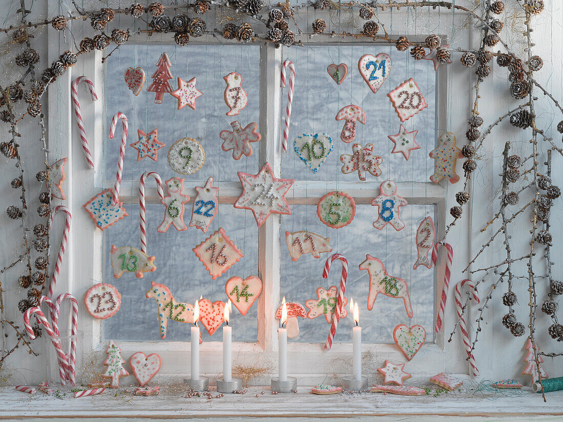 Fenster dekoriert als Adventskalender mit nummerierten Keksen