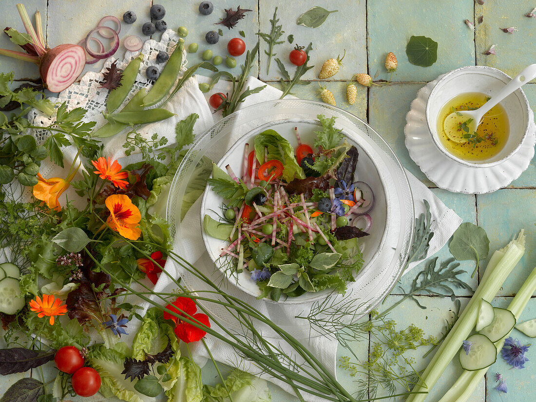 Plate of fresh salad surrounded by ingredients